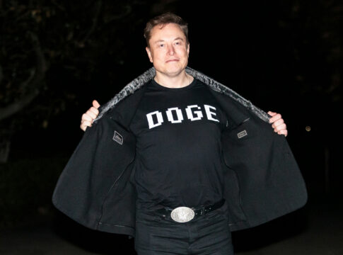 Man opening his coat to show a graphic T-shirt at night
