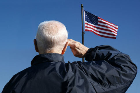 Elderly man saluting the American flag