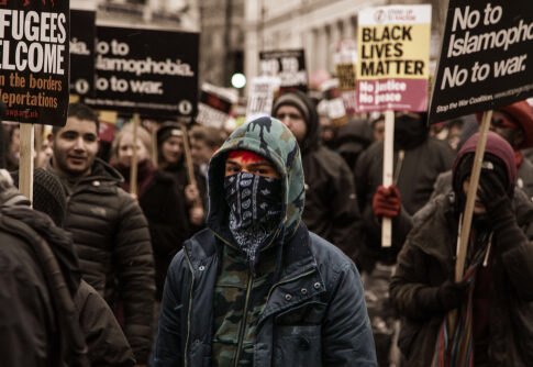 A diverse group of protesters holding signs during a march for social justice