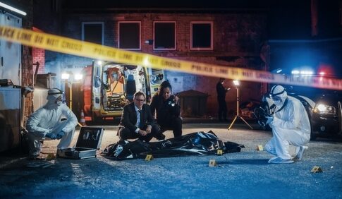 Police and forensic team investigating a crime scene in a dark alley