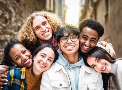 Group of friends smiling closely together outdoors