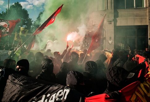 Crowd of protesters with smoke flares and flags during a demonstration